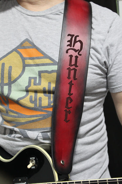 A man wearing a non-stitched red leather strap with black around the border and the word Hunter engraved on it. 